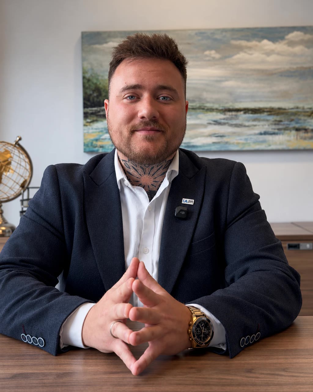 Maxime Patry à son bureau, souriant, les mains jointes sur la table